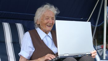 Ältere Dame sitzt lachend vor einem Laptop | © fotolia_meseritsch_innsbruck_25273042